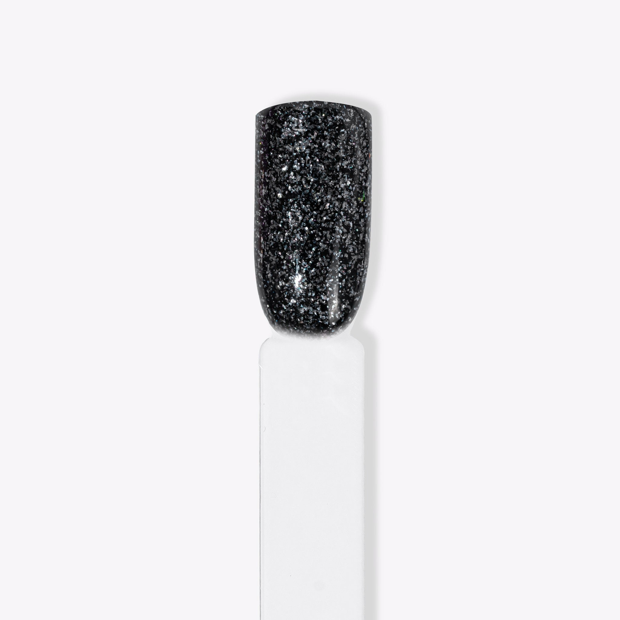 Närbild av Glow Down mörkt kolnagellack med silverglitter för naglar hemma och nageltrender 2024. Idealisk för hållbara naglar med nagelkit och gellack, gnistrar även i mörkret